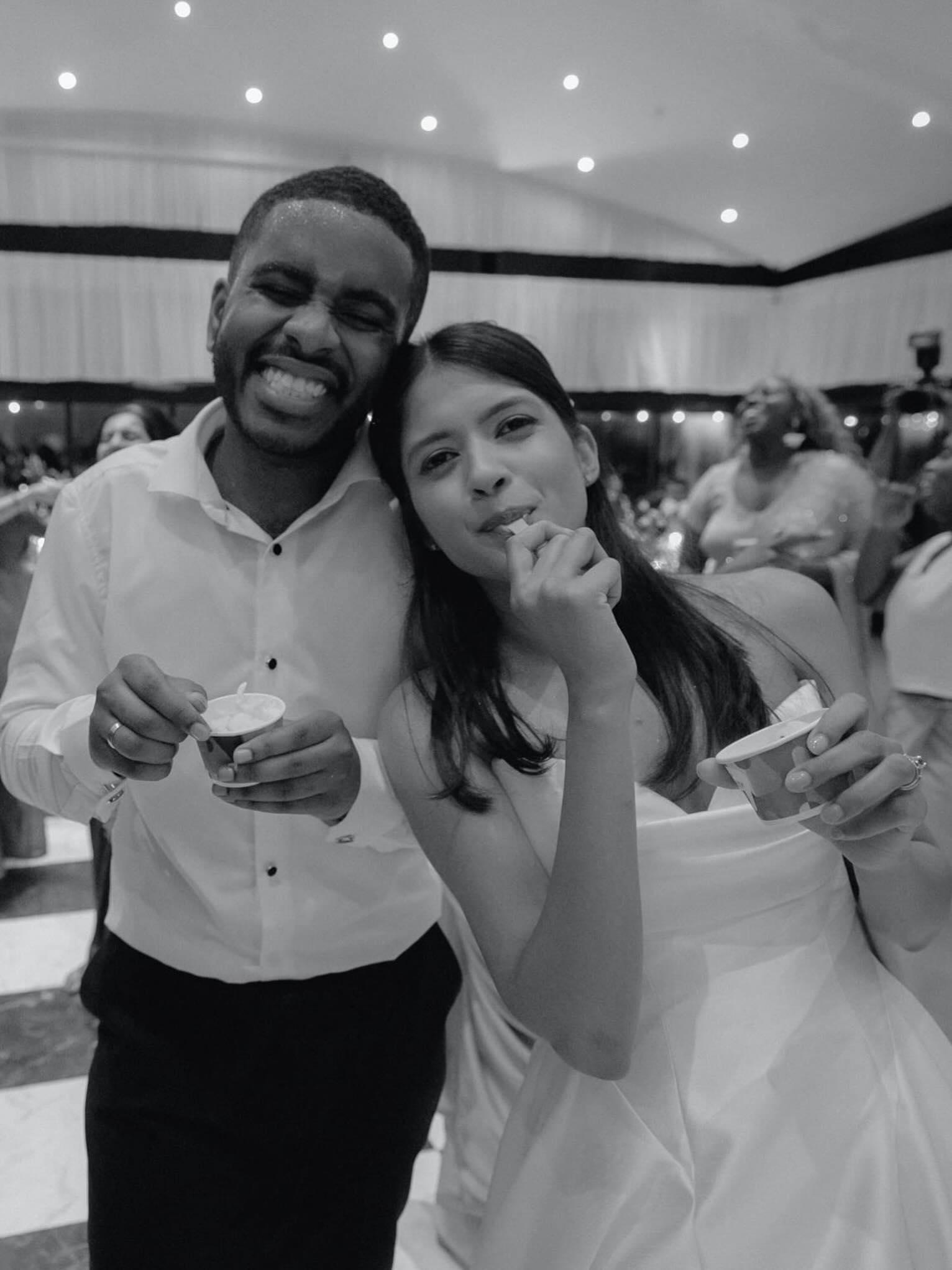 Couple laughing with ice cream cups at a wedding