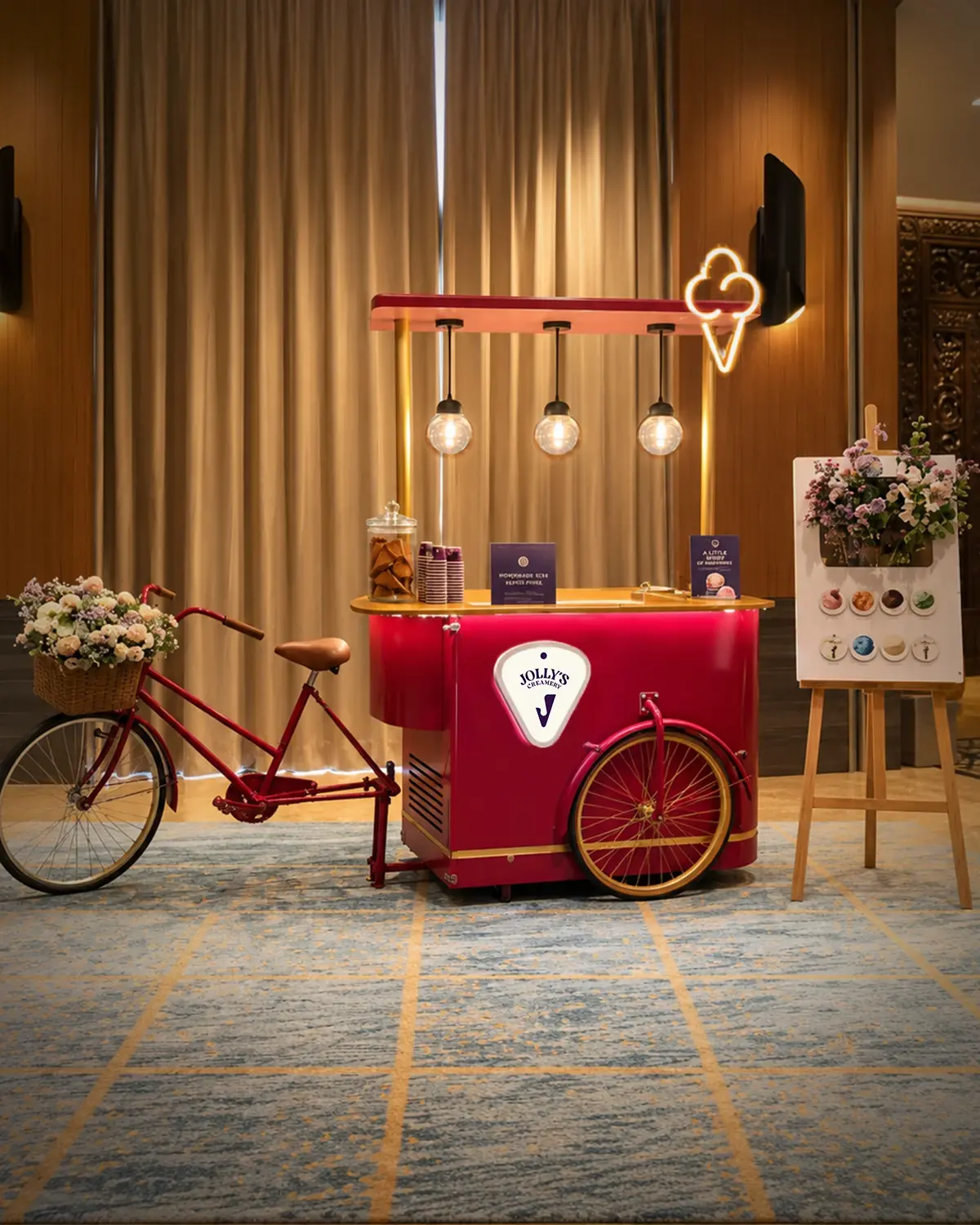 Ferrari Red Jolly's cart with a red bicycle and flower basket in a curtained hotel ballroom